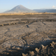 The Engare Sero footprint site. An eruption of Oldoinyo L’engai (the volcano in the background) generated the ash in which the footprints were preserved.